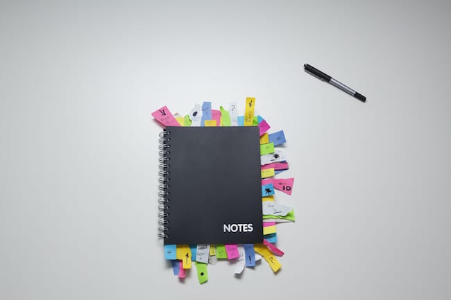 notebook with dozens of sticky notes showing disorganization